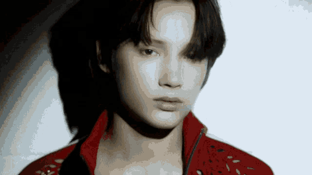 a close up of a person 's face with a red jacket on .