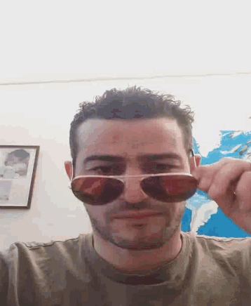 a man wearing sunglasses looks at the camera