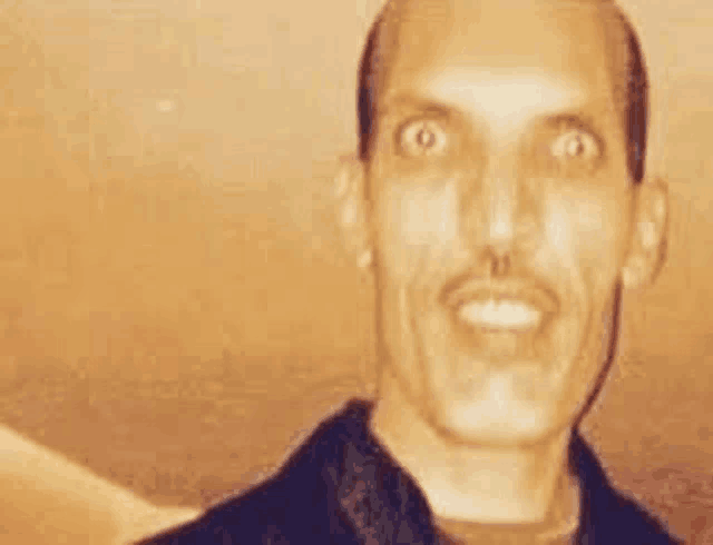 a close up of a man with a mustache smiling .