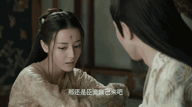 a woman with a red circle on her forehead looks at a man