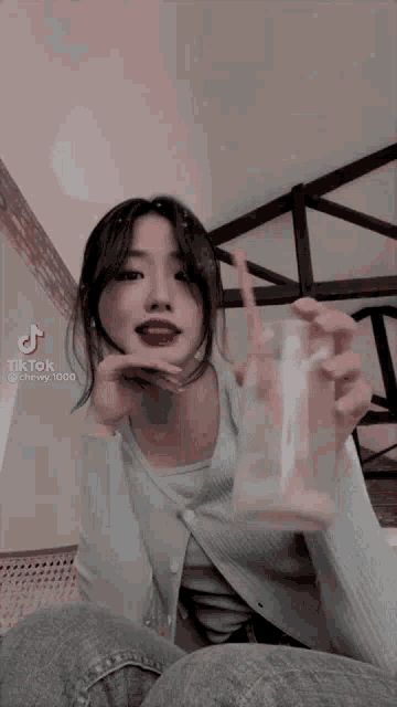 a girl is holding a glass of water with a straw .