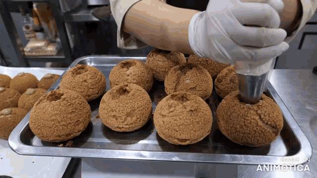 a tray of cupcakes is being decorated by a person with the words made in animatica on the bottom