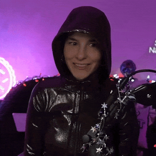 a woman wearing a black hooded jacket is smiling
