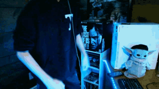 a man playing a video game with a box that says the last of us part 2 on it