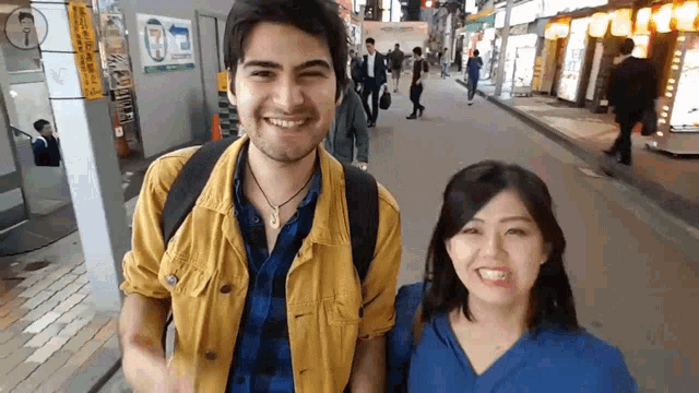 a man and a woman are standing next to each other on a street
