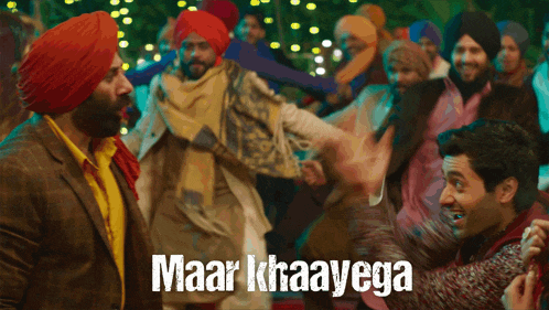a group of people are dancing and the words maar khaavega are on the screen