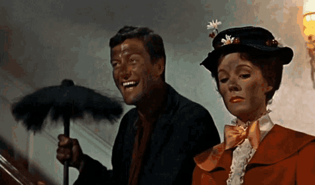 a man and a woman are standing next to each other holding umbrellas