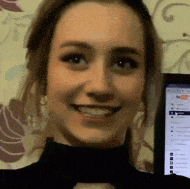 a close up of a woman 's face with a computer screen in the background