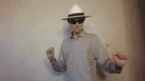 a man wearing a hat and sunglasses dancing