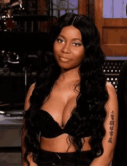 a woman with a tattoo on her arm is wearing a bra