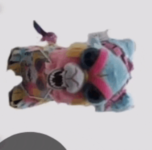 a stuffed animal with its mouth open is laying on its back on a white background .