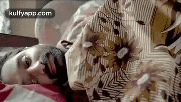 a man with a black mask on his face is sleeping in a bed .