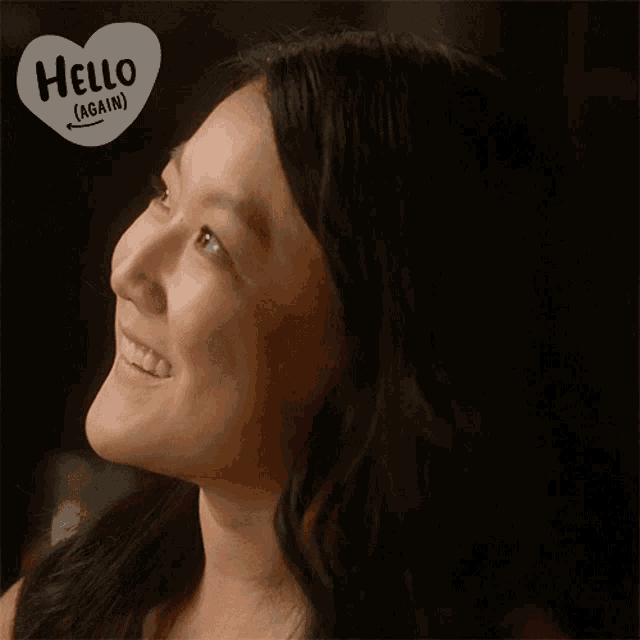 a woman is smiling with a hello again sticker on her face