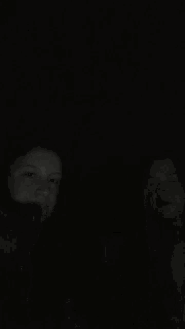 a woman is laying on a bed in the dark .
