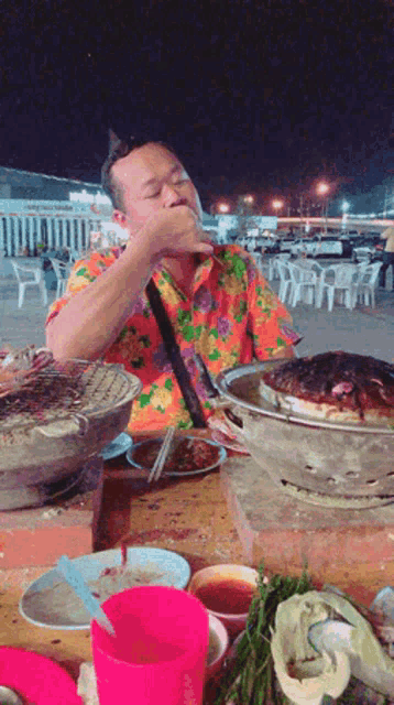 a man sitting at a table with plates of food on it