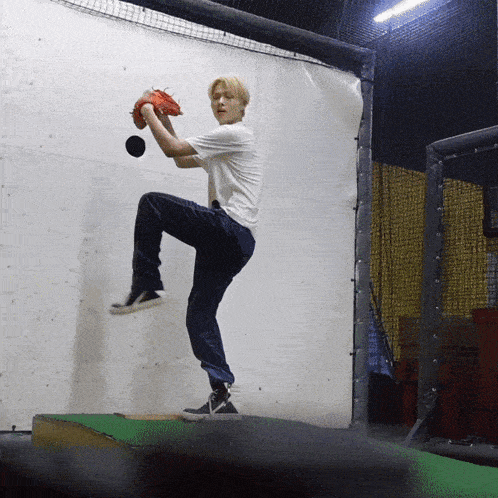 a young man in a white shirt is throwing a ball