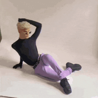 a person laying on the floor wearing purple pants and a black top