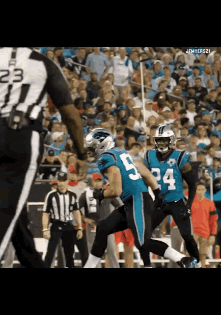a football player with the number 5 on his jersey runs towards a referee