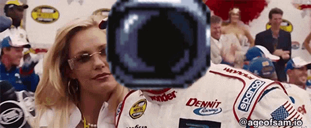 a woman is looking at a race car driver wearing a dennit jersey