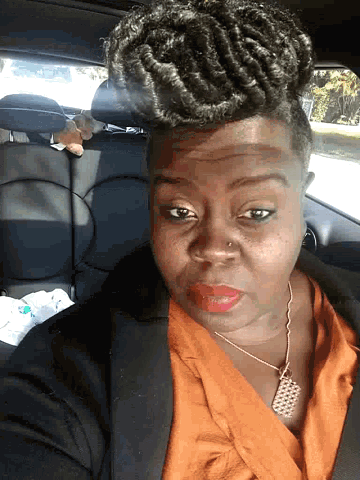 a woman with braids is sitting in a car
