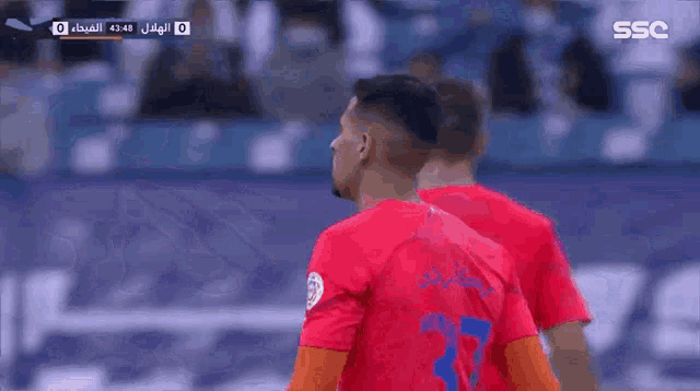 a soccer player wearing a red and blue jersey with the number 37 on it
