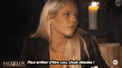 a blonde woman is sitting in front of a candle and says bachelor .