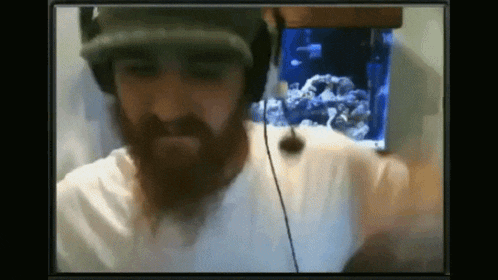 a man with a beard wears headphones and a hat