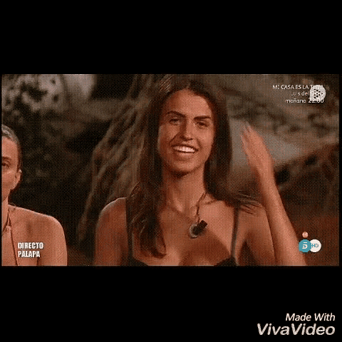 a woman in a bikini is laughing while holding her hair in a video made with vivavideo .