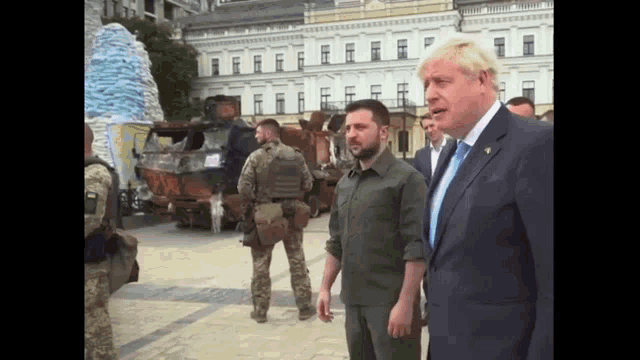 a man in a suit and tie talks to another man