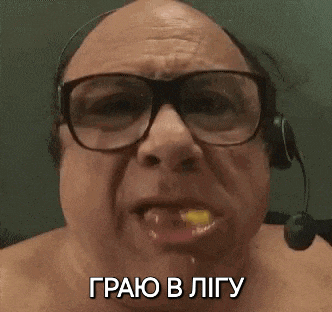 a bald man wearing glasses and a headset is eating a piece of food .
