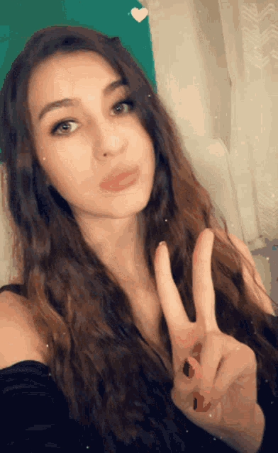 a woman giving a peace sign with her fingers