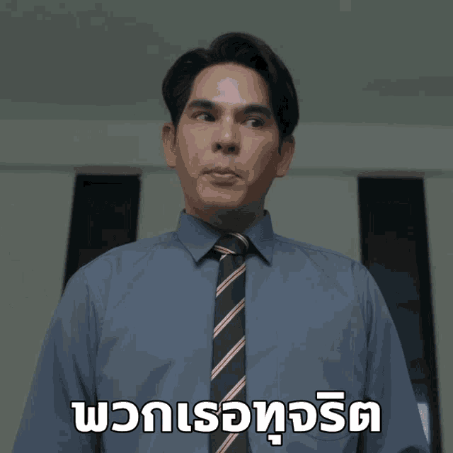 a man wearing a blue shirt and tie with a foreign language caption
