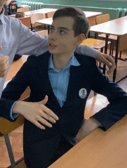 a boy in a suit has a badge on his jacket that says 1