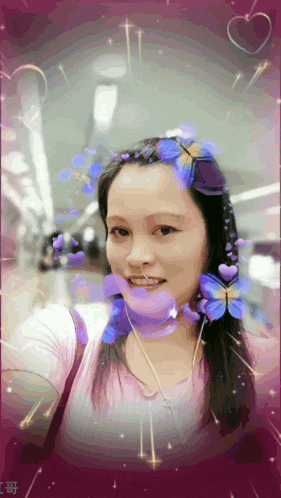a woman in a pink shirt with purple flowers on her hair