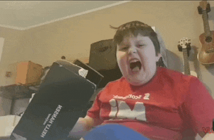 a boy wearing a red shirt with the number 2 on it is yelling
