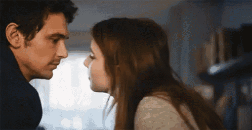 a man and a woman are kissing each other in a room .