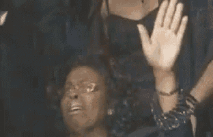 a woman is laughing with her hands in the air .