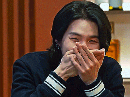 a man is covering his mouth with his hands while smiling