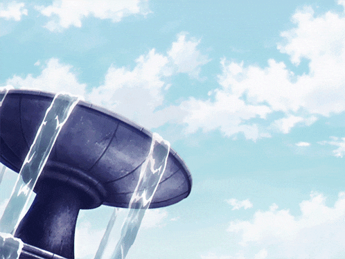 a fountain with water coming out of it against a blue sky with clouds