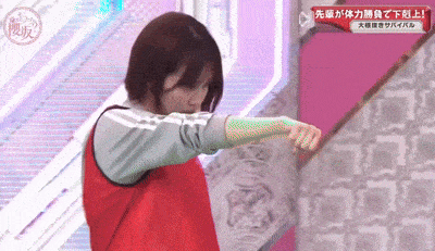 a woman in a red shirt is standing in front of a pink wall with chinese writing on it