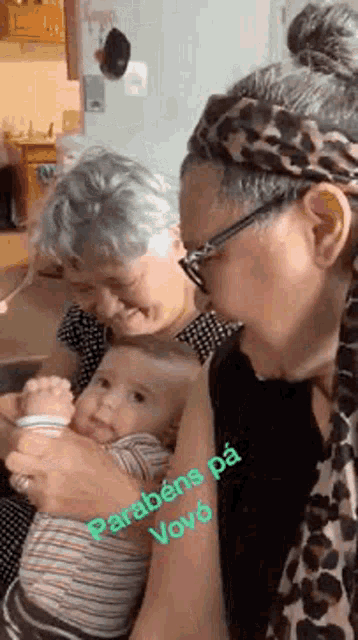 a woman is holding a baby in her arms while two other women look on .