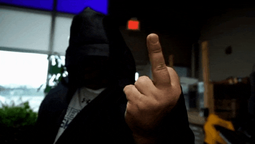 a man wearing a hooded jacket giving the middle finger