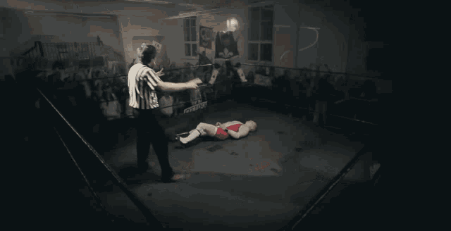 a wrestler in a blue and white singlet is wrestling another wrestler in a black and white singlet