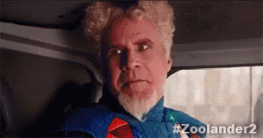 a man with a beard and curly hair is sitting in a car wearing a superhero costume .