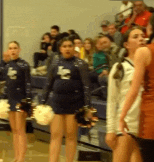 a group of cheerleaders are standing in front of a crowd with the letter l on their uniforms
