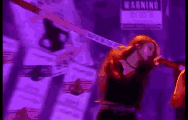 a woman is standing in front of a purple sign that says `` morning mafia '' .