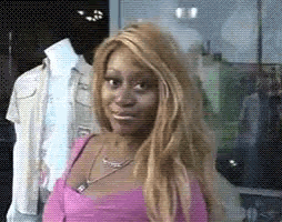 a woman with blonde hair is wearing a pink shirt and necklace