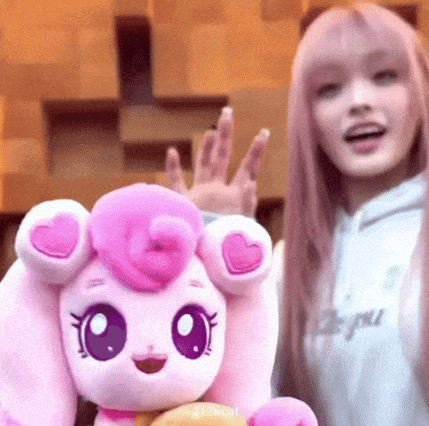 a woman is standing next to a pink stuffed animal .