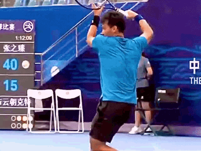 a man in a blue shirt is swinging a tennis racquet while playing tennis