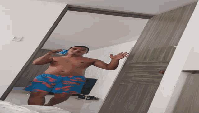 a shirtless man is taking a picture of himself in the mirror
